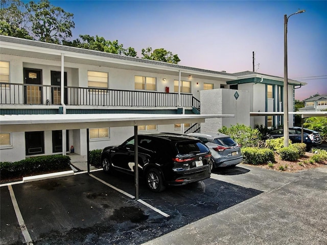 property at dusk featuring covered parking