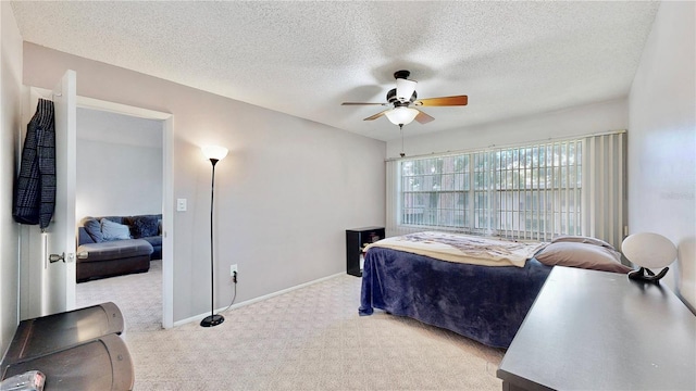 bedroom featuring ceiling fan, light carpet, and a textured ceiling