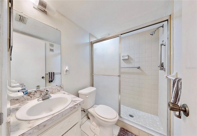 bathroom with vanity, tile patterned floors, toilet, and an enclosed shower