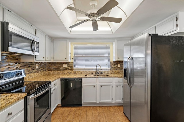 kitchen featuring appliances with stainless steel finishes, white cabinetry, light stone countertops, and ceiling fan