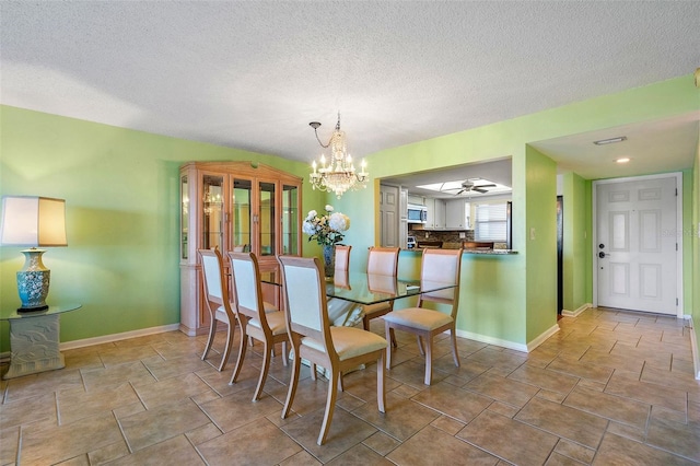 dining room with a textured ceiling and ceiling fan with notable chandelier