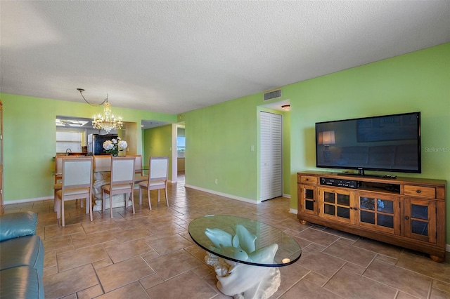 living room featuring a chandelier and a textured ceiling