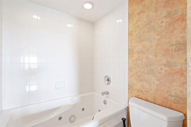 bathroom featuring tiled shower / bath and toilet