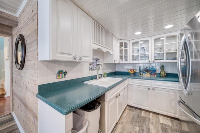 kitchen featuring light hardwood / wood-style flooring, stainless steel refrigerator, sink, and white cabinetry