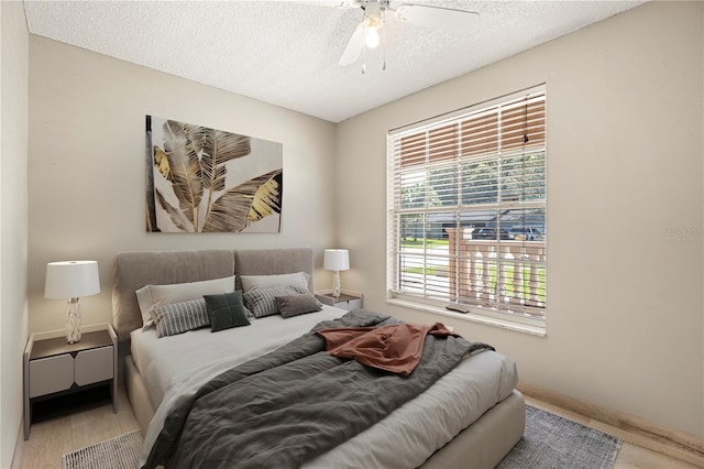 bedroom featuring a textured ceiling, ceiling fan, and wood-type flooring