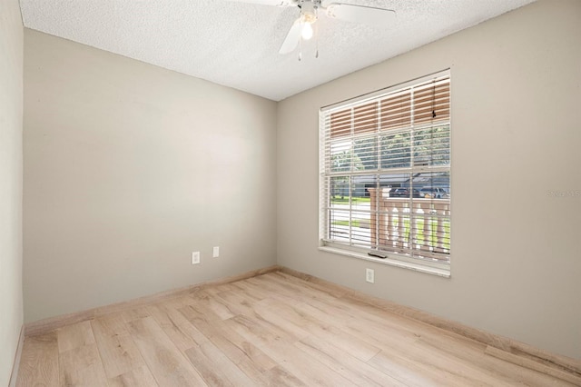 unfurnished room featuring light wood-type flooring, ceiling fan, and a textured ceiling