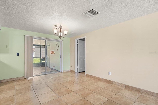 unfurnished room featuring a textured ceiling, a chandelier, and light tile patterned flooring