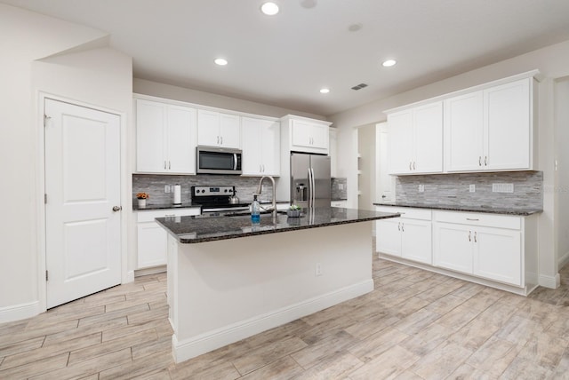 kitchen with a center island with sink, appliances with stainless steel finishes, white cabinets, and light hardwood / wood-style floors