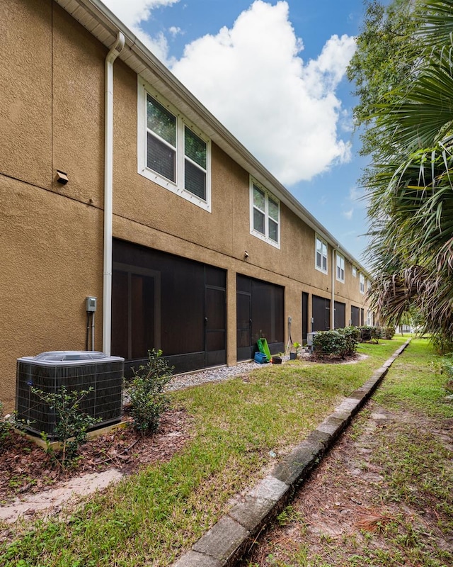 back of house featuring a lawn and central AC