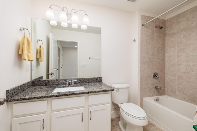 full bathroom featuring vanity, toilet, tiled shower / bath combo, and tile patterned floors