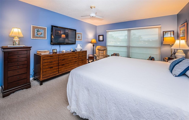 carpeted bedroom with ceiling fan and a textured ceiling