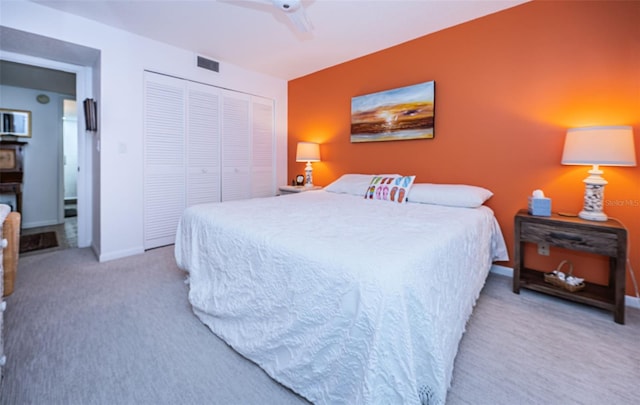 carpeted bedroom featuring ceiling fan and a closet