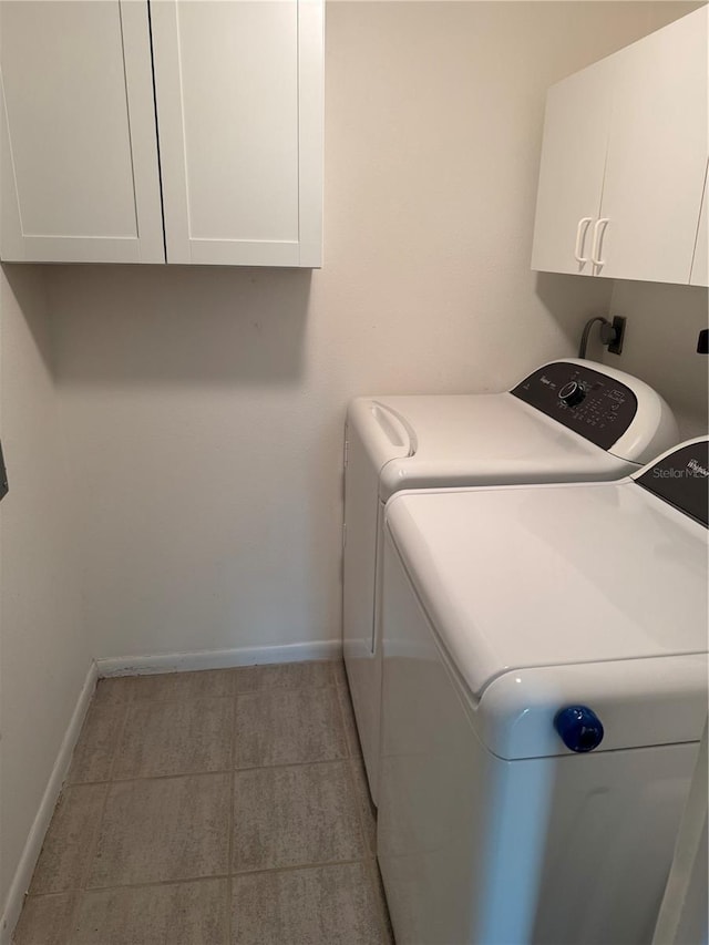 laundry area featuring washing machine and dryer and cabinets