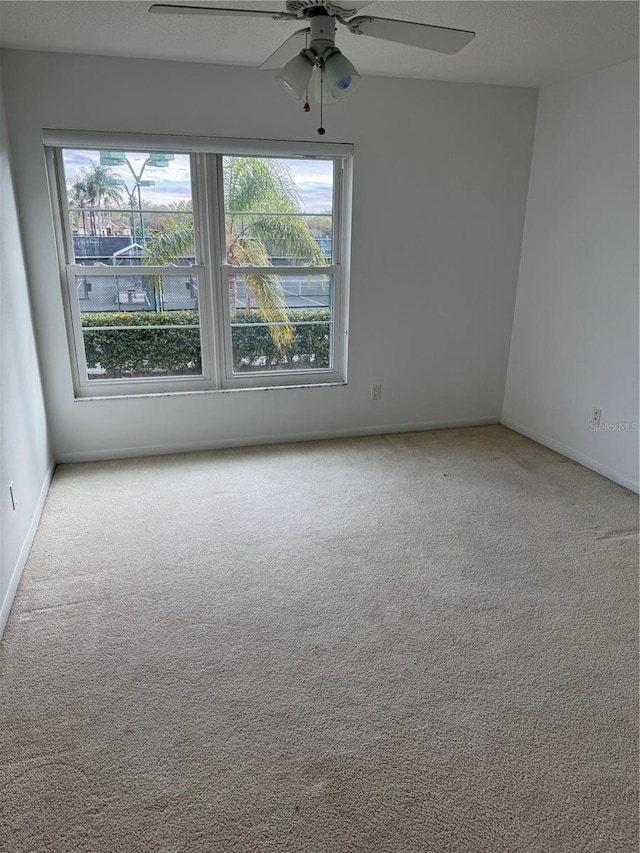 carpeted spare room with ceiling fan