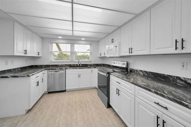 3021 Countryside Blvd Unit 28A, Clearwater, FL 33761 - kitchen with sink, white cabinetry, appliances with stainless steel finishes, and dark stone counters
