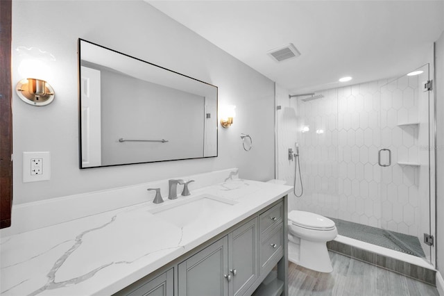 3021 Countryside Blvd Unit 28A, Clearwater, FL 33761 - bathroom featuring wood-type flooring, toilet, vanity, and a tile shower