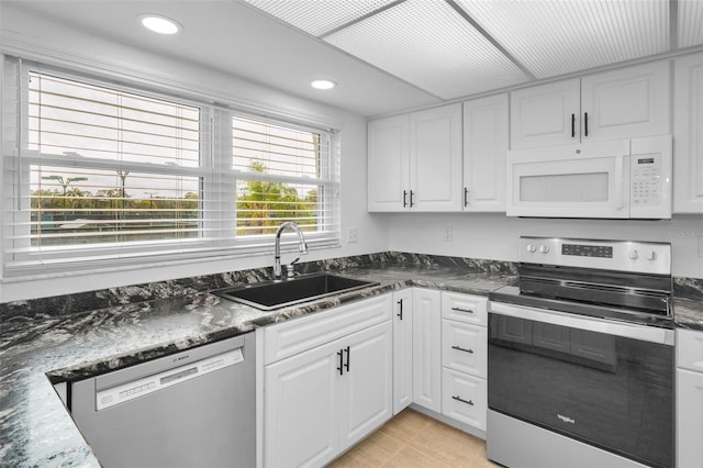3021 Countryside Blvd Unit 28A, Clearwater, FL 33761 - kitchen with dark stone counters, sink, stainless steel appliances, and white cabinetry