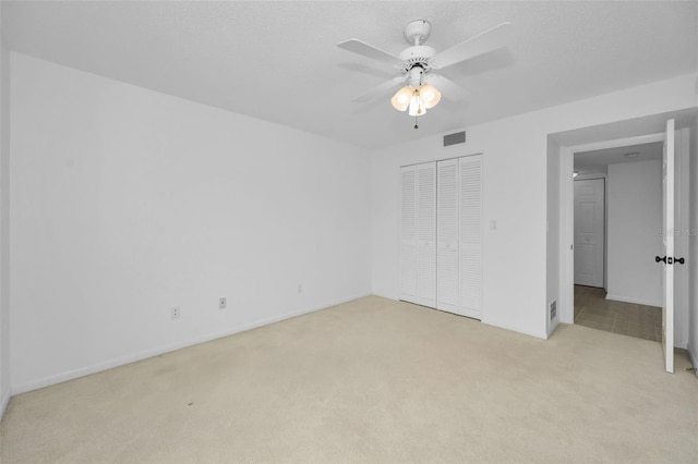 3021 Countryside Blvd Unit 28A, Clearwater, FL 33761 - unfurnished bedroom with light carpet, ceiling fan, and a closet
