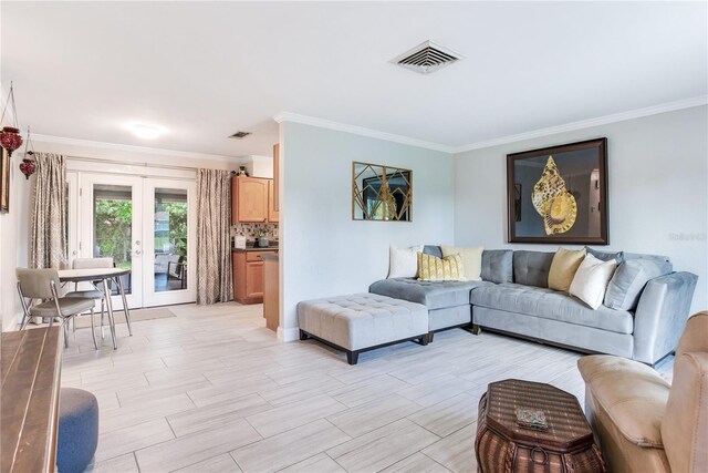 living room featuring light hardwood / wood-style flooring, ornamental molding, and french doors