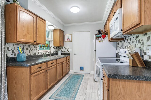 kitchen with crown molding, white appliances, sink, and tasteful backsplash