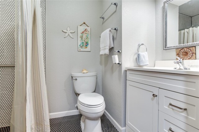 bathroom featuring tile patterned flooring, vanity, and toilet