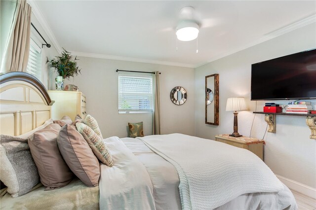 bedroom featuring ceiling fan, ornamental molding, and light wood-type flooring