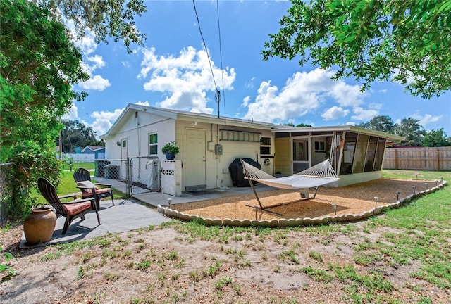 back of property with a patio and a sunroom