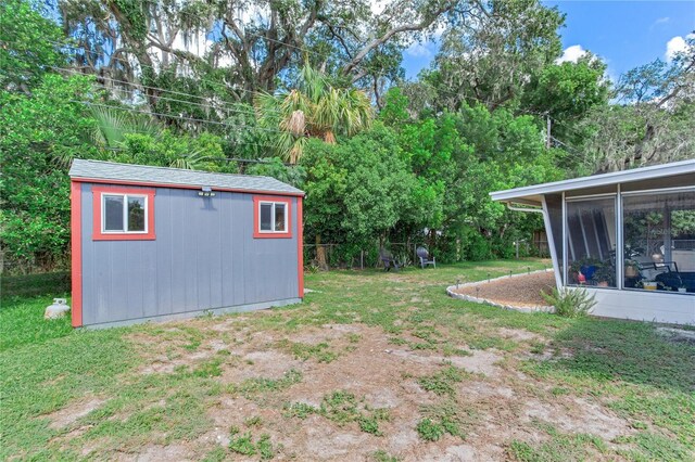 view of yard with a storage unit and a sunroom