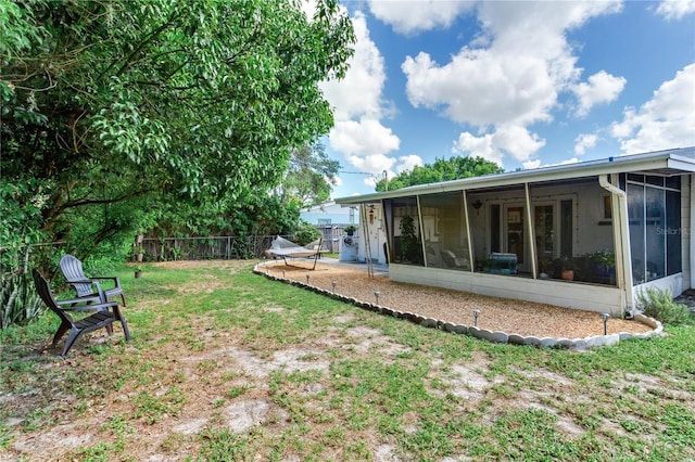 view of yard featuring a sunroom and a patio area