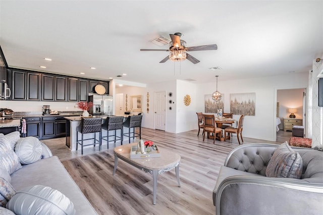 living room featuring ceiling fan and light wood-type flooring