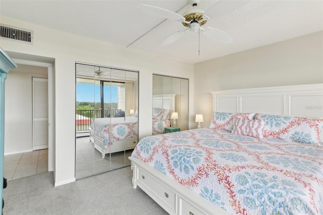 bedroom with light tile patterned floors, two closets, access to exterior, and ceiling fan