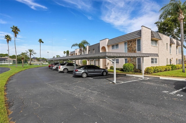 view of vehicle parking featuring a yard and a carport