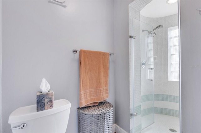 bathroom featuring toilet and a shower with door