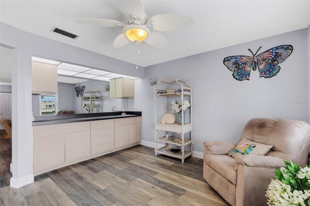 living room with ceiling fan, sink, and light hardwood / wood-style flooring