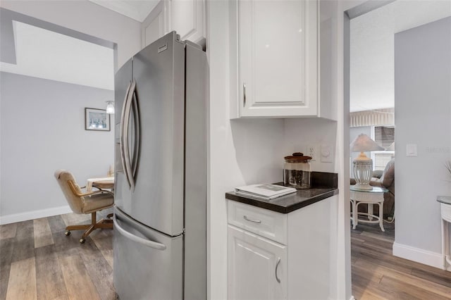 kitchen with wood-type flooring, white cabinetry, and stainless steel refrigerator with ice dispenser