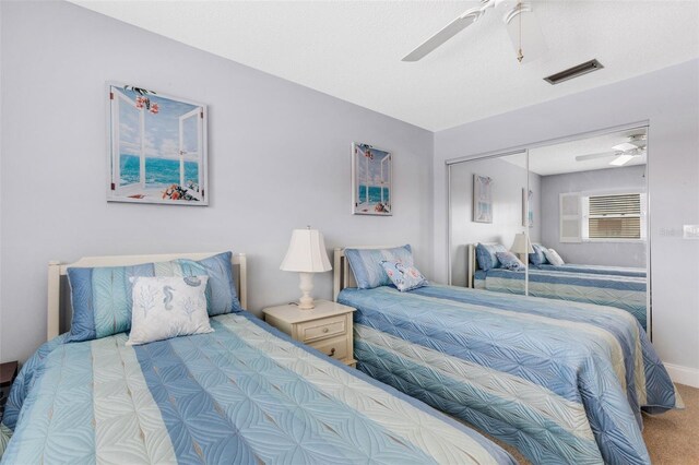 carpeted bedroom with ceiling fan and a closet