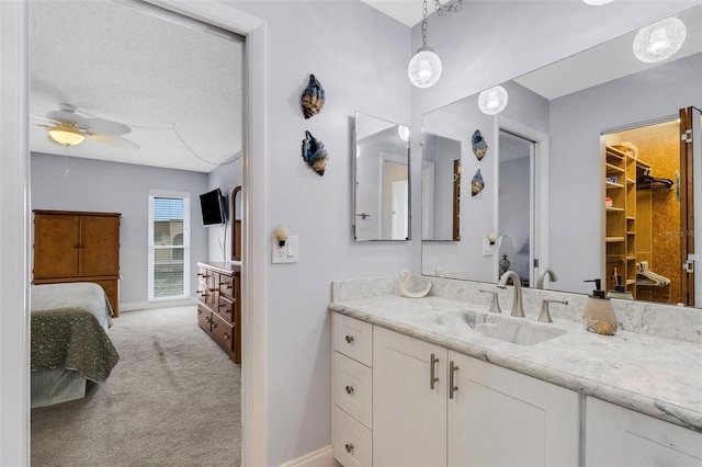 bathroom featuring ceiling fan, a textured ceiling, and vanity