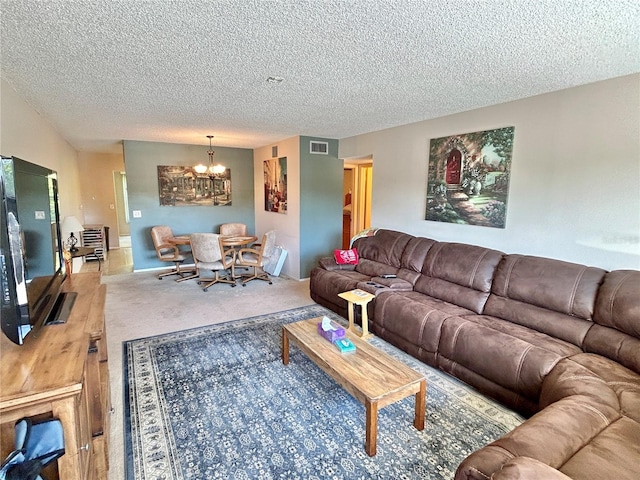 living room featuring an inviting chandelier and a textured ceiling