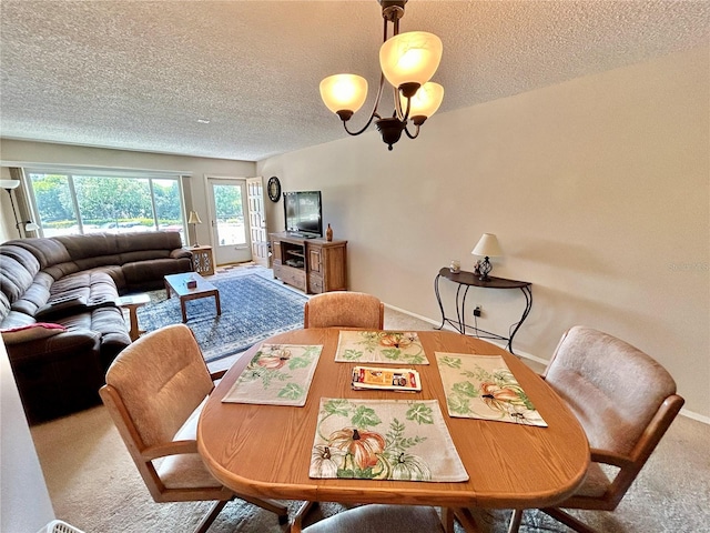 dining area with carpet, a notable chandelier, and a textured ceiling