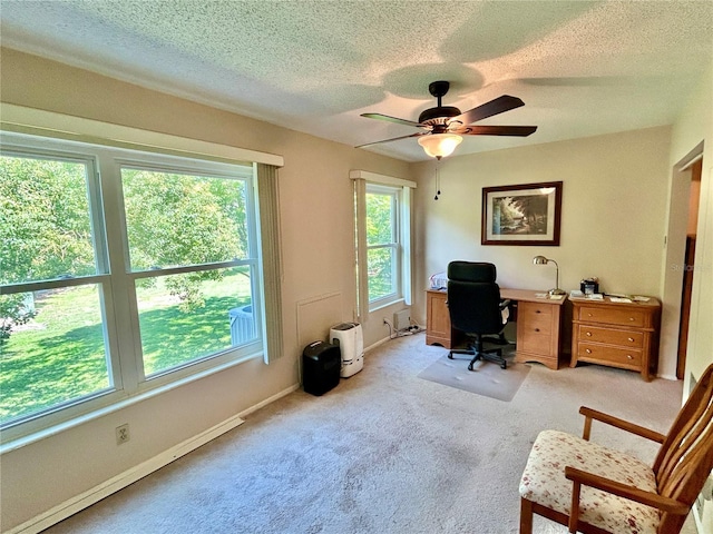 carpeted home office with a textured ceiling, a baseboard radiator, and ceiling fan