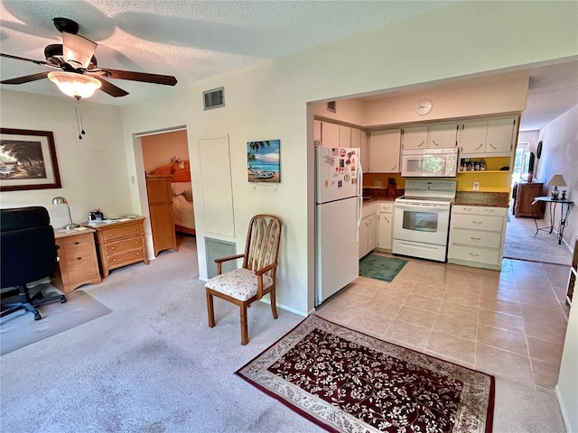 interior space with white appliances, light colored carpet, a textured ceiling, and ceiling fan