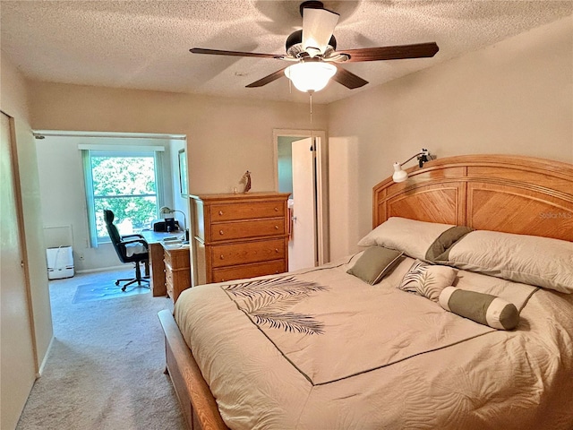 bedroom featuring carpet flooring, a textured ceiling, and ceiling fan