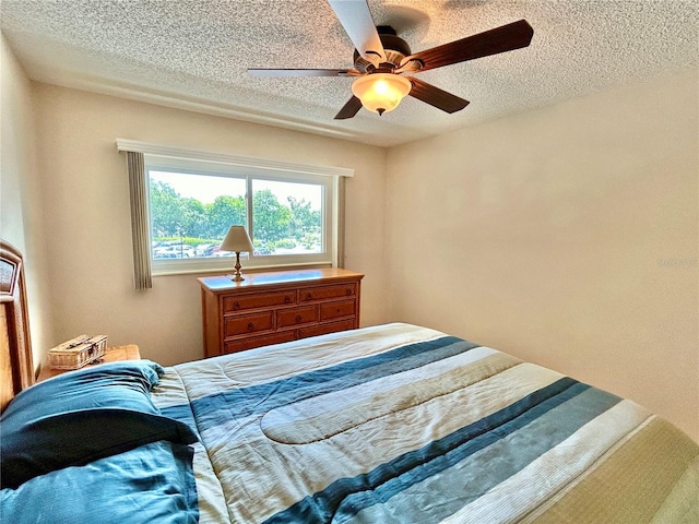 bedroom with a textured ceiling and ceiling fan