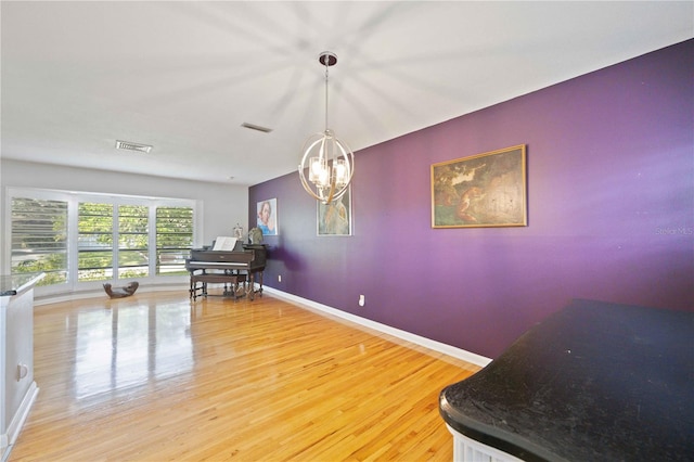 dining space with hardwood / wood-style floors and a chandelier