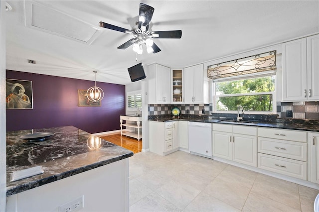 kitchen with white dishwasher, decorative light fixtures, white cabinets, and sink