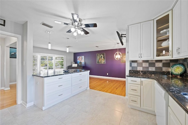 kitchen with decorative backsplash, dishwasher, white cabinets, and hanging light fixtures