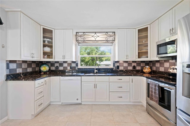 kitchen featuring decorative backsplash, stainless steel appliances, sink, white cabinetry, and light tile patterned flooring