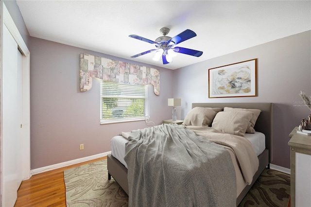 bedroom featuring ceiling fan, a closet, and hardwood / wood-style flooring