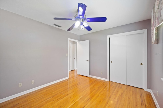 unfurnished bedroom with ceiling fan, a closet, and light wood-type flooring