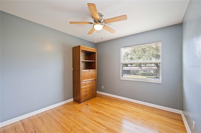 empty room with ceiling fan and light hardwood / wood-style floors